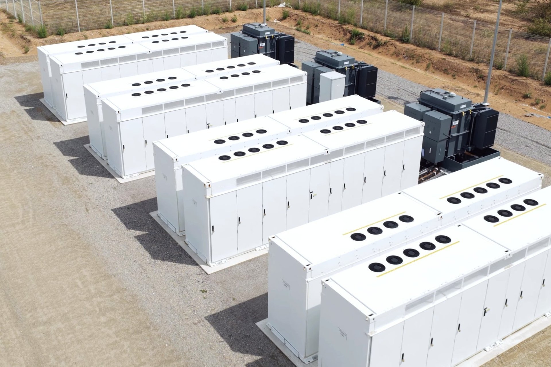 Battery storage units and transformers on a gravel site pad